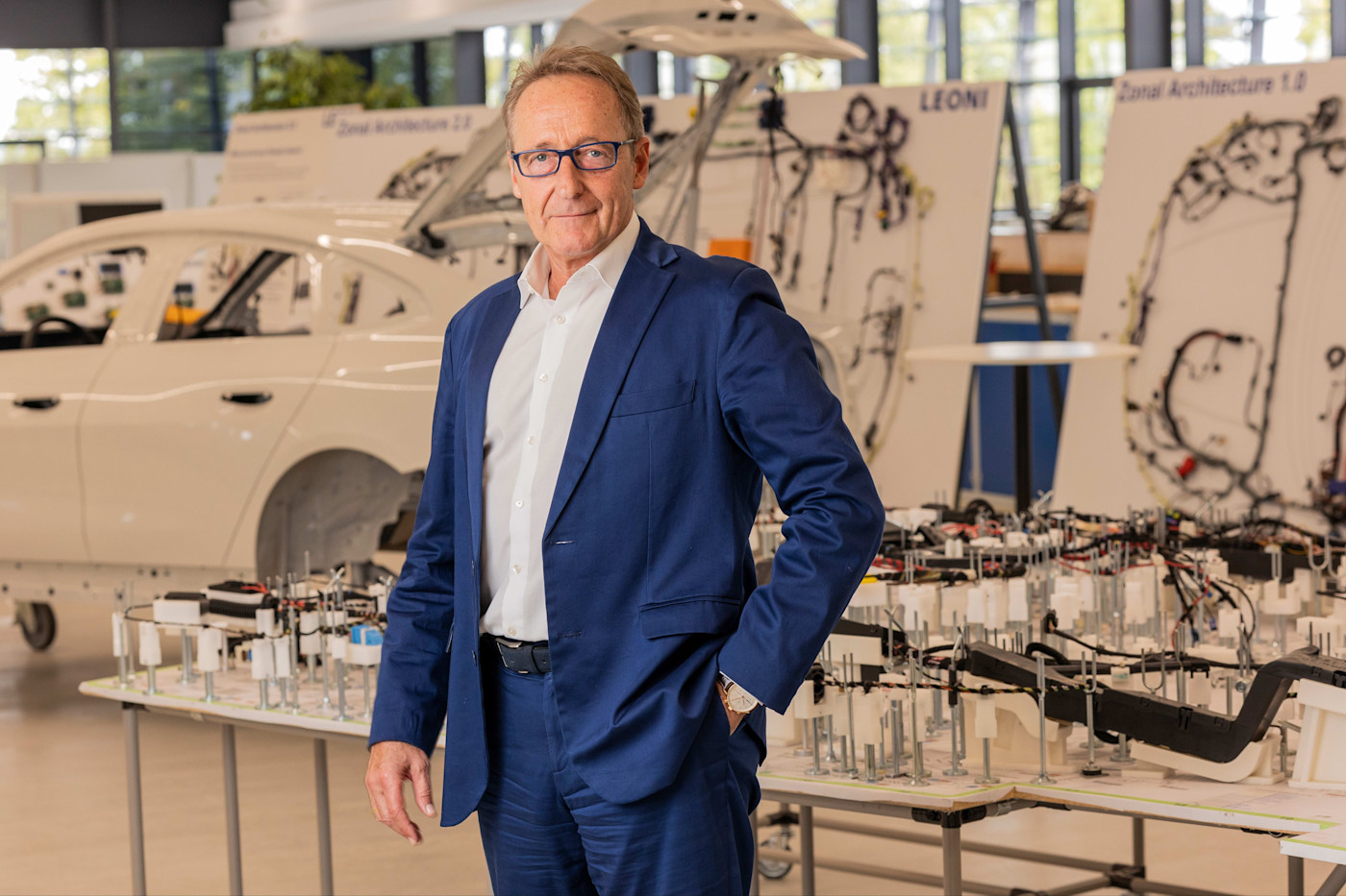 Leoni Innovation & Collaboration Centre에서 자동차 배선 전시물과 차체 앞에 서 있는 Klaus Rinnerberger