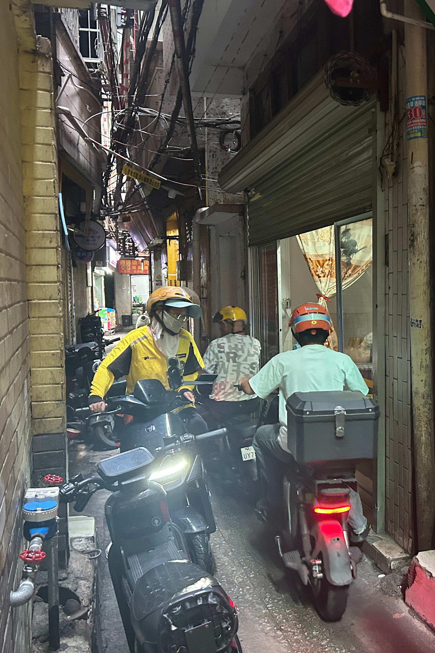 스파이촌의 한 골목에서 메이퇀[왼쪽]과 타오바오 배달 기사들이 서로 비켜 지나가고 있다