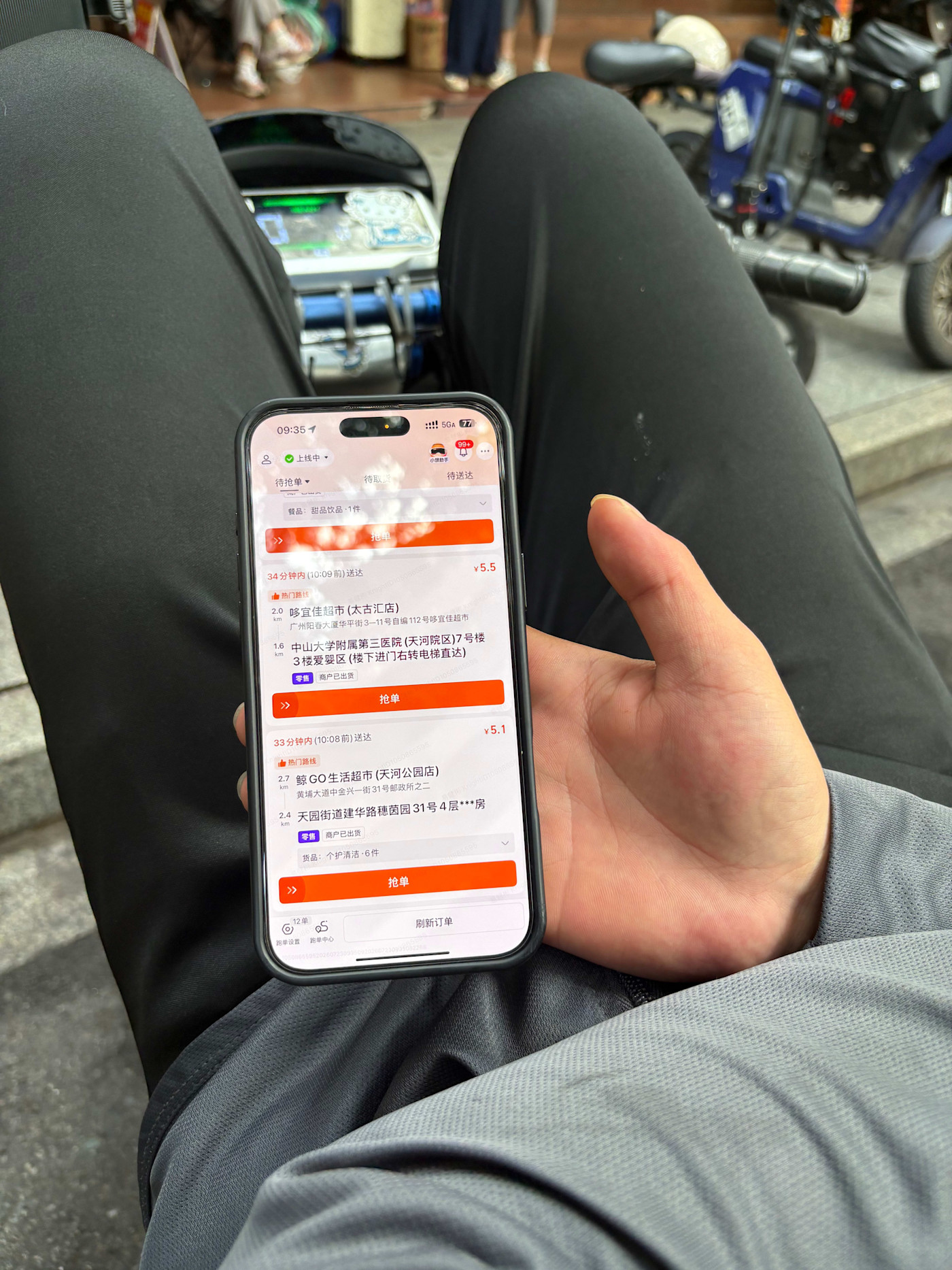 타오바오 배달기사가 자전거에서 쉬며 주문을 찾는 데 사용하는 앱을 보여주고 있다