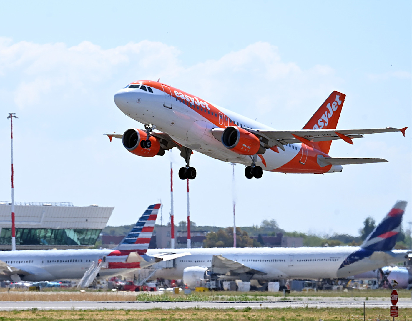 레오나르도 다빈치 국제공항에서 이륙하는 easyJet 에어버스 A320, 배경에 다른 항공기들이 보인다.