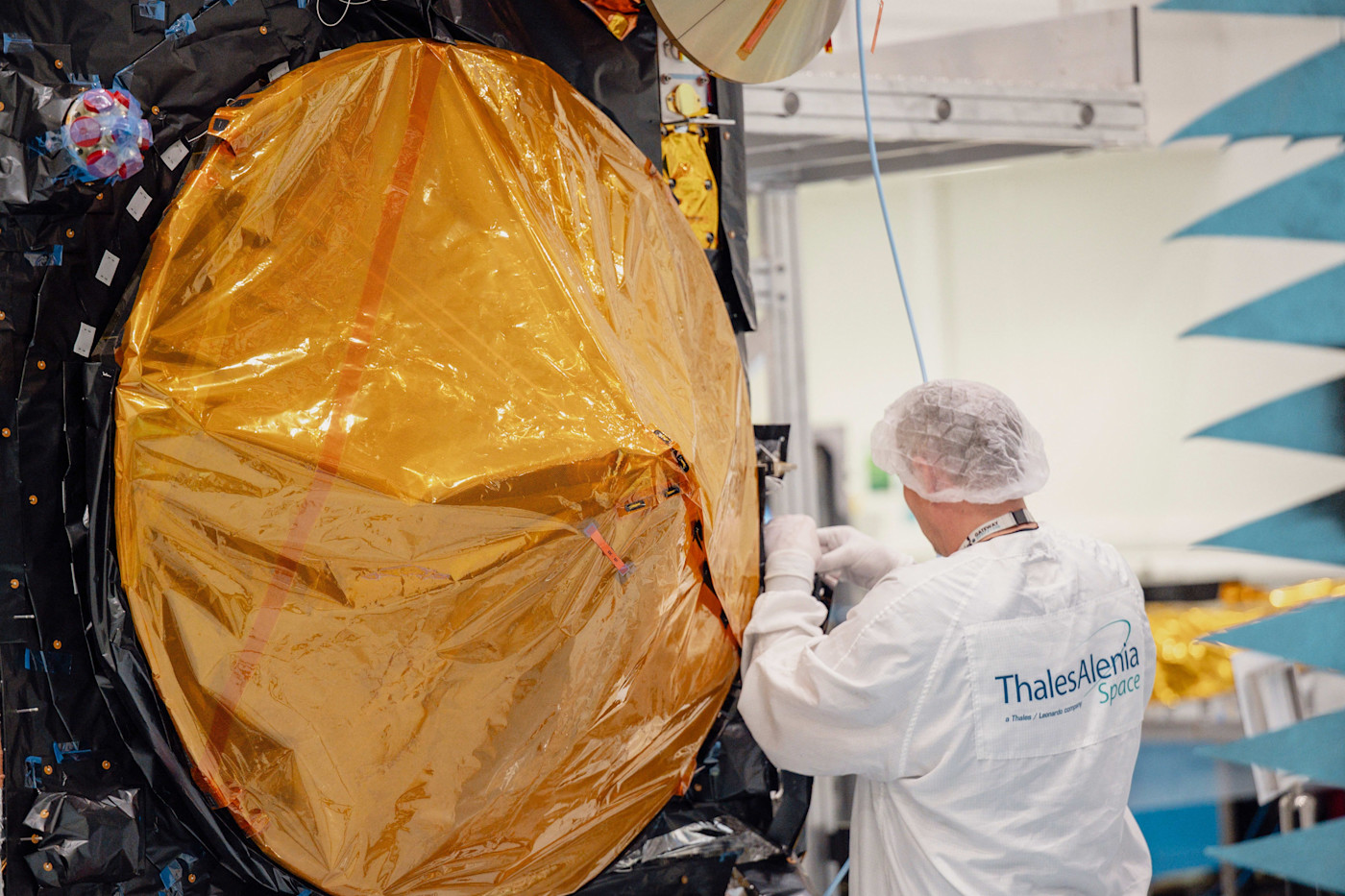 Thales Alenia Space 실험복을 입은 직원이 금박으로 감싼 Sentinel-3C 서비스 모듈을 작업하고 있다.