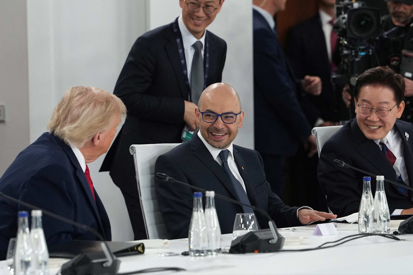 G7 정상회의에서 회의 테이블을 사이에 두고 미소를 지으며 대화하는 도널드 트럼프와 데미스 허사비스.