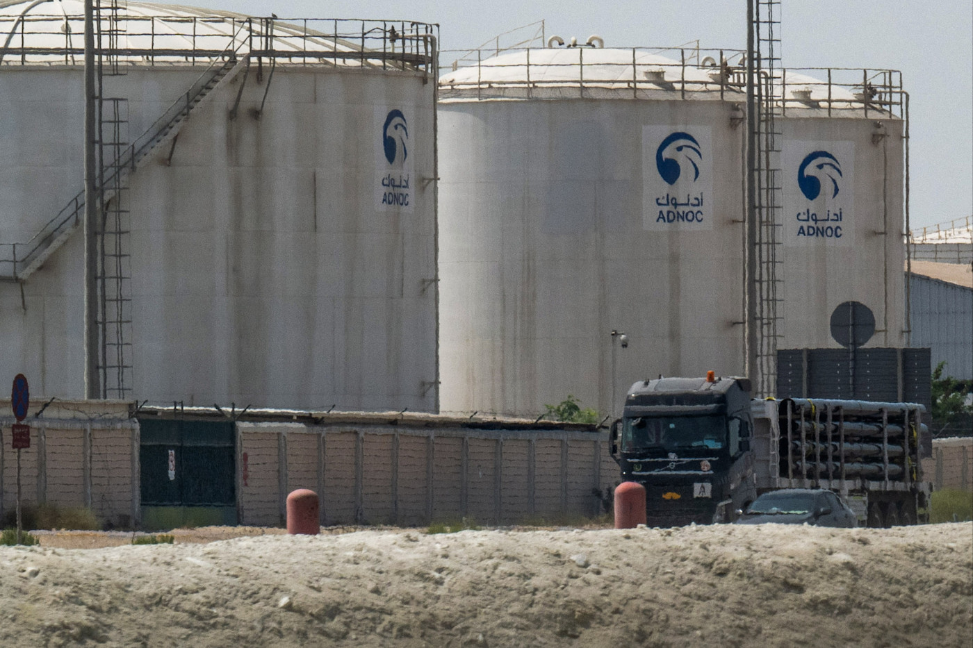 아부다비의 한 시설에서 대형 ADNOC Gas 저장 탱크 옆을 지나는 트럭