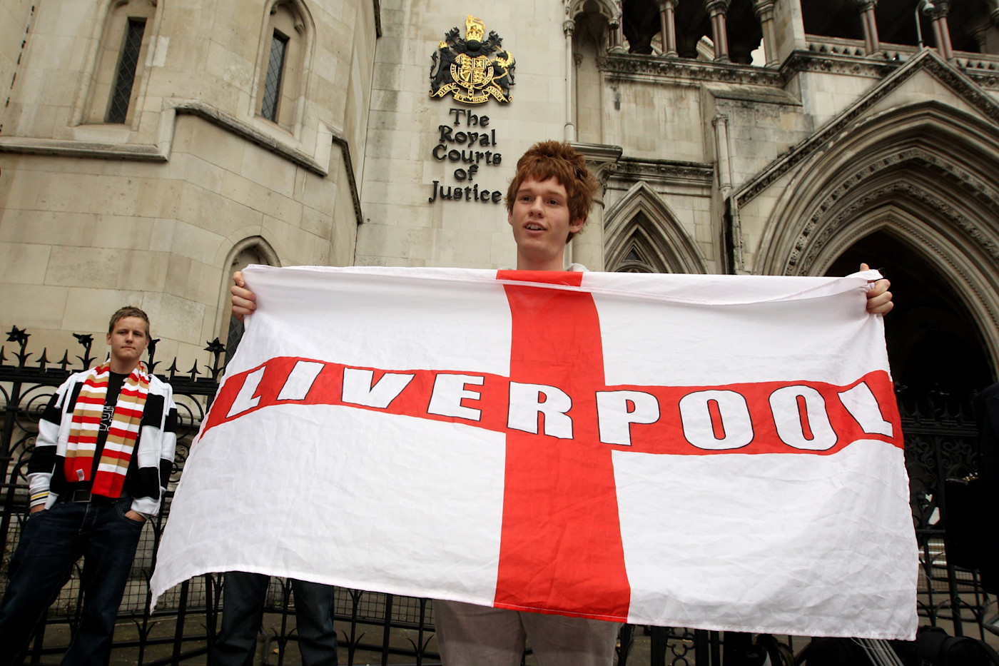 리버풀 풋볼 클럽 팬이 왕립법원 밖에서 ‘Liverpool’이라고 적힌 대형 깃발을 들고 있다.