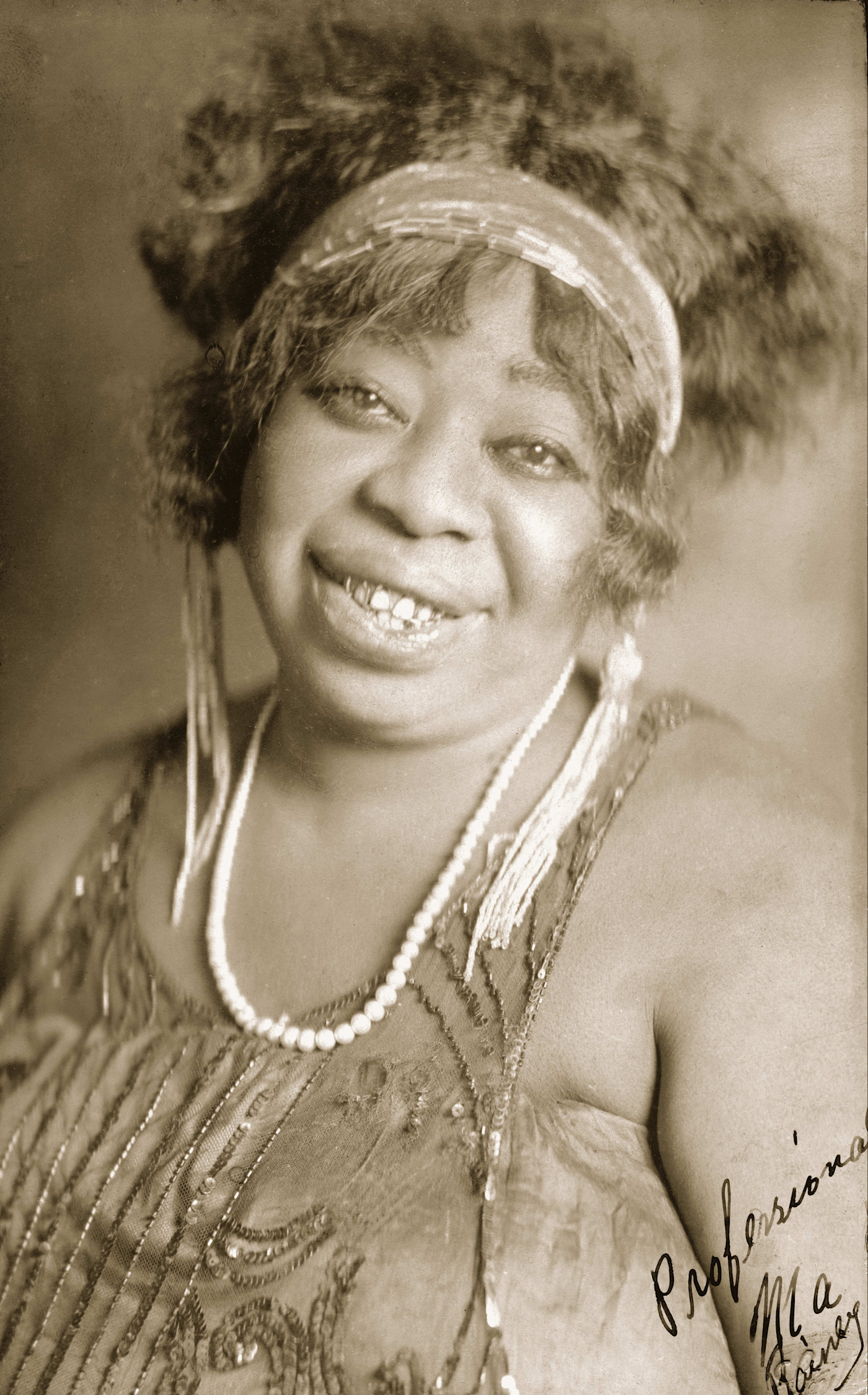 1923년 Paramount Records 홍보 사진에서 구슬 장식 머리띠와 진주 목걸이, 스팽글 드레스를 착용한 Ma Rainey가 카메라를 향해 미소 짓고 있다.
