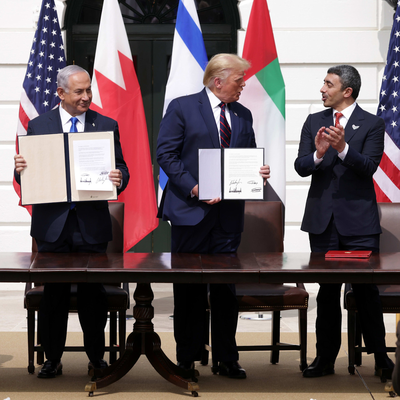 Benjamin Netanyahu, Donald Trump, Abdullah bin Zayed bin Sultan Al Nahyan이 아브라함 협정 체결식에서 서명한 문서를 들고 있다.