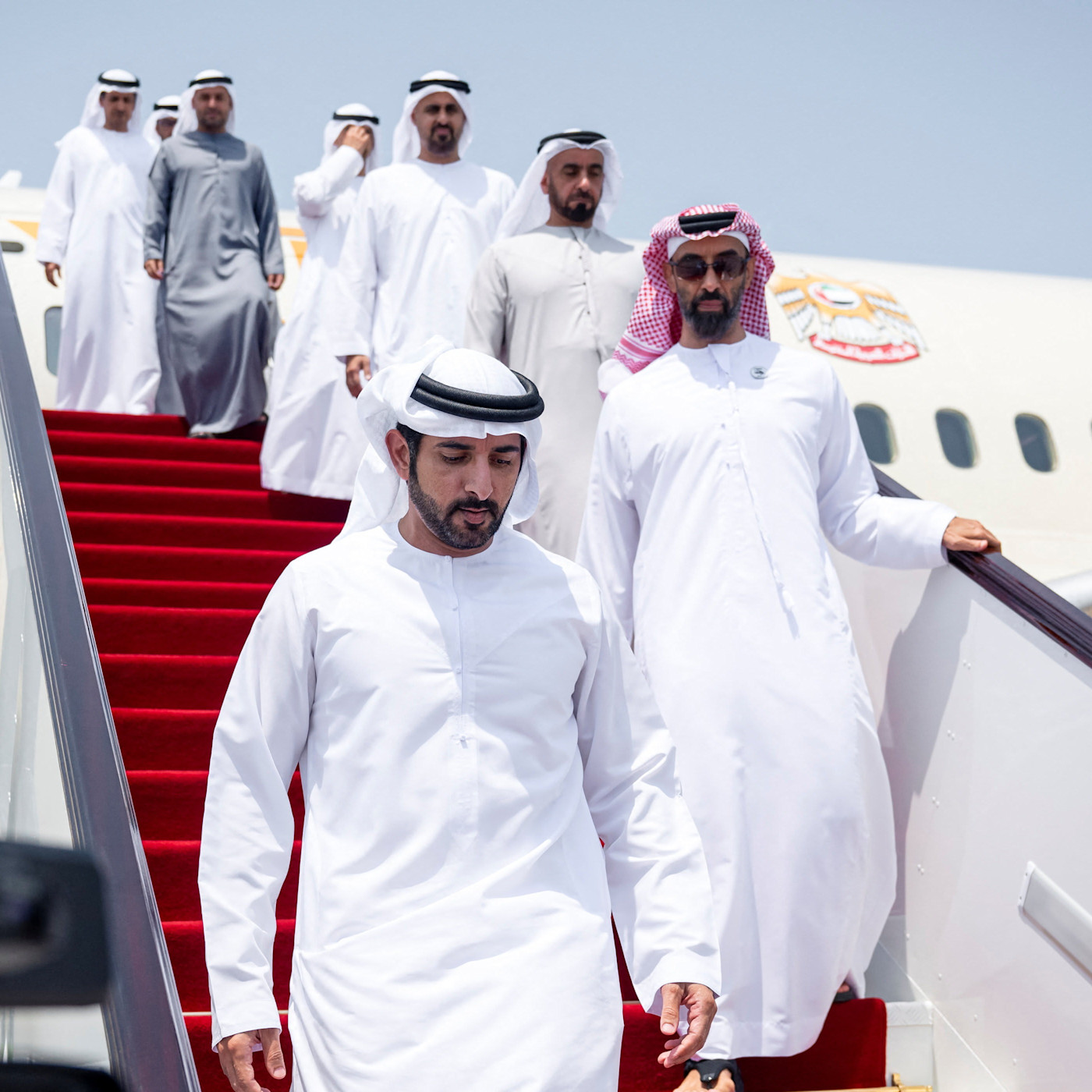 도하에서 수행원들과 함께 비행기 계단을 내려오는 Sheikh Hamdan bin Mohamed Al Maktoum과 Sheikh Tahnoon bin Zayed Al Nahyan