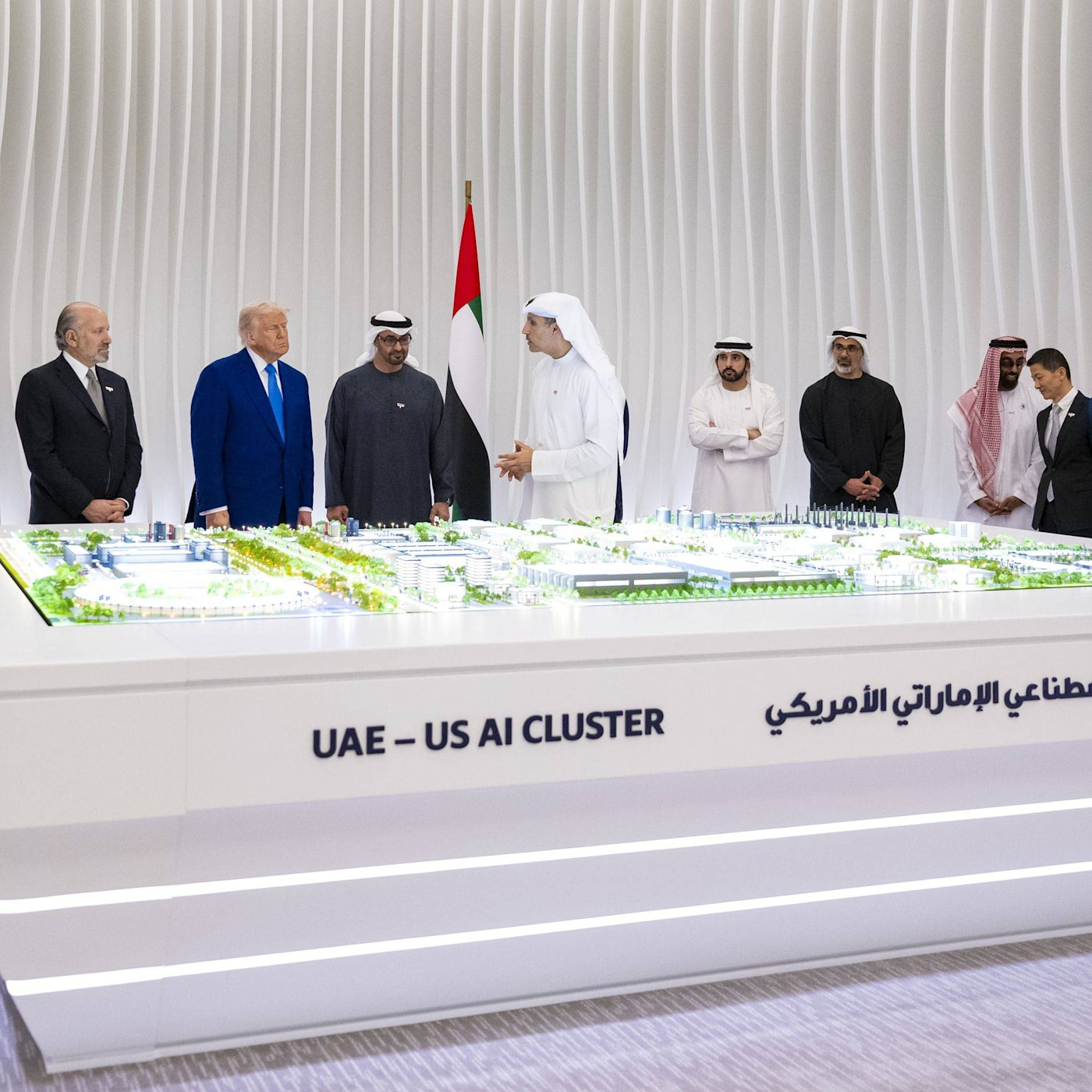 Mohammed bin Zayed Al Nahyan과 Donald Trump이 ‘UAE-US AI CLUSTER’라고 적힌 전시 모형 주변에서 관계자들과 함께 서 있다.