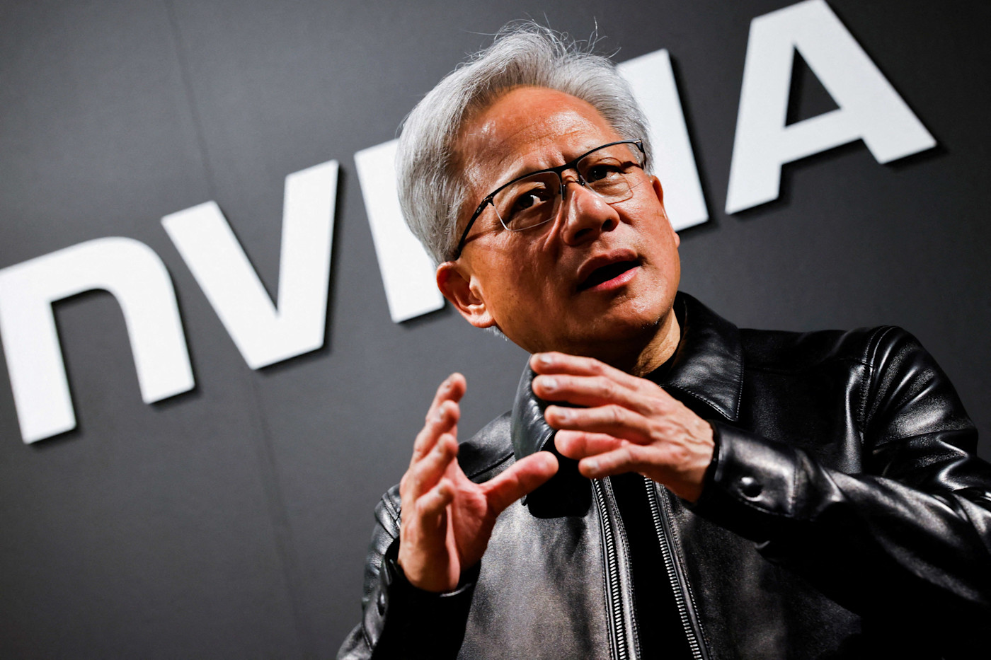 Nvidia CEO Jensen Huang이 말하는 가운데 손짓하고 있으며, 배경에 Nvidia 로고 일부가 보인다.
