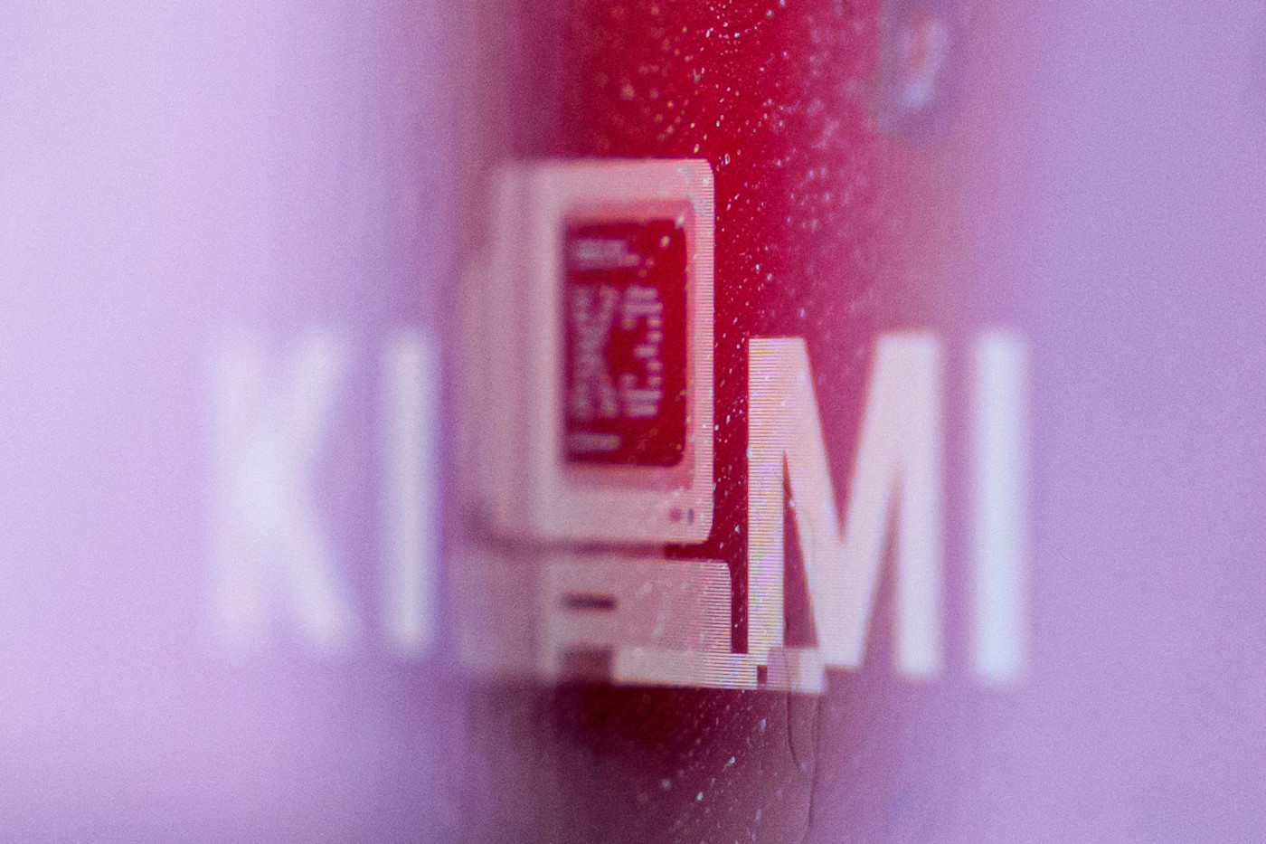 Kimi K3 웹사이트의 흐릿한 분홍색과 빨간색 배경 위에 ‘KIMI’라는 단어와 컴퓨터 아이콘이 흰색으로 표시돼 있다.