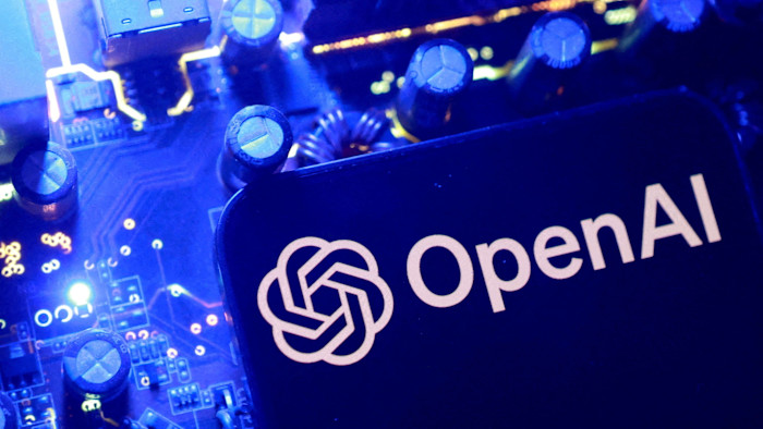 어두운 배경에 파란 조명으로 회로 기판 부품이 보이고 OpenAI 로고가 표시된 일러스트.