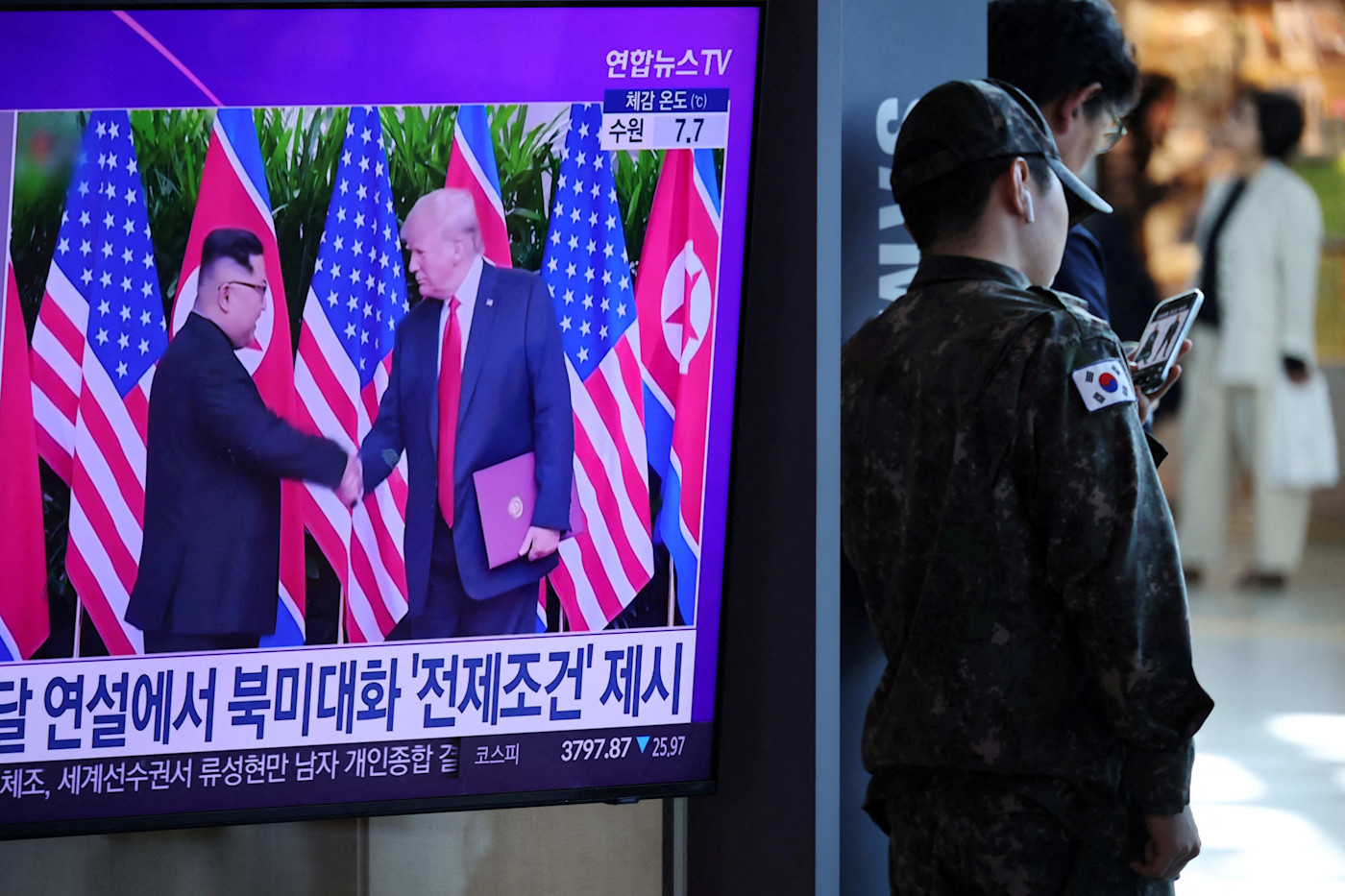 지난해 서울의 한 기차역에서 북한 김정은 국무위원장과 도널드 트럼프 미국 대통령의 정상회담 가능성을 보도하는 TV 옆에 서 있는 한국군 병사