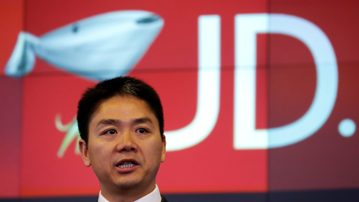리처드 류가 화면에 표시된 대형 JD.com 로고 앞에서 발언하고 있다.