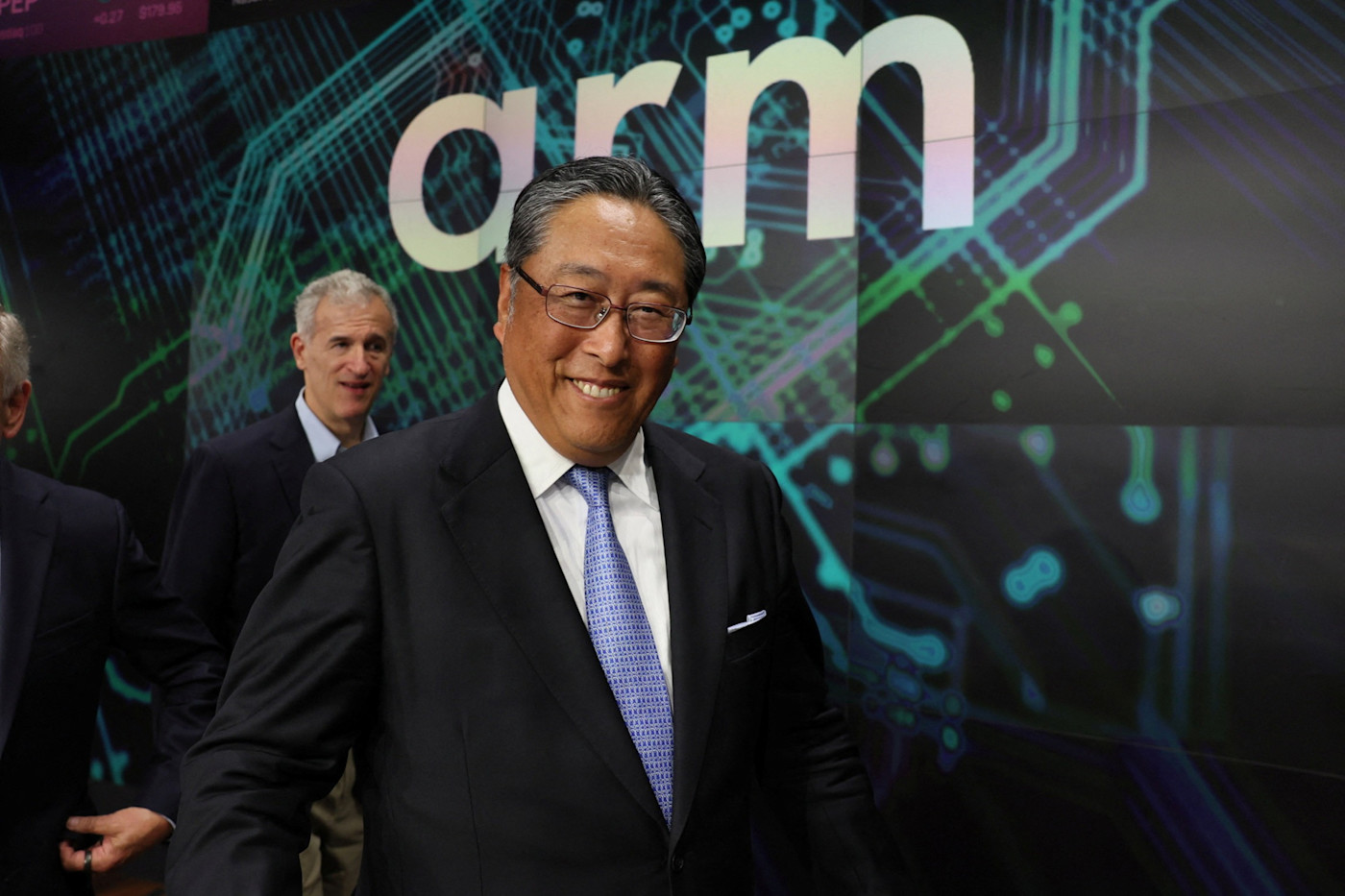 Arm 로고 표지판 앞에서 미소 짓는 요시미쓰 고토