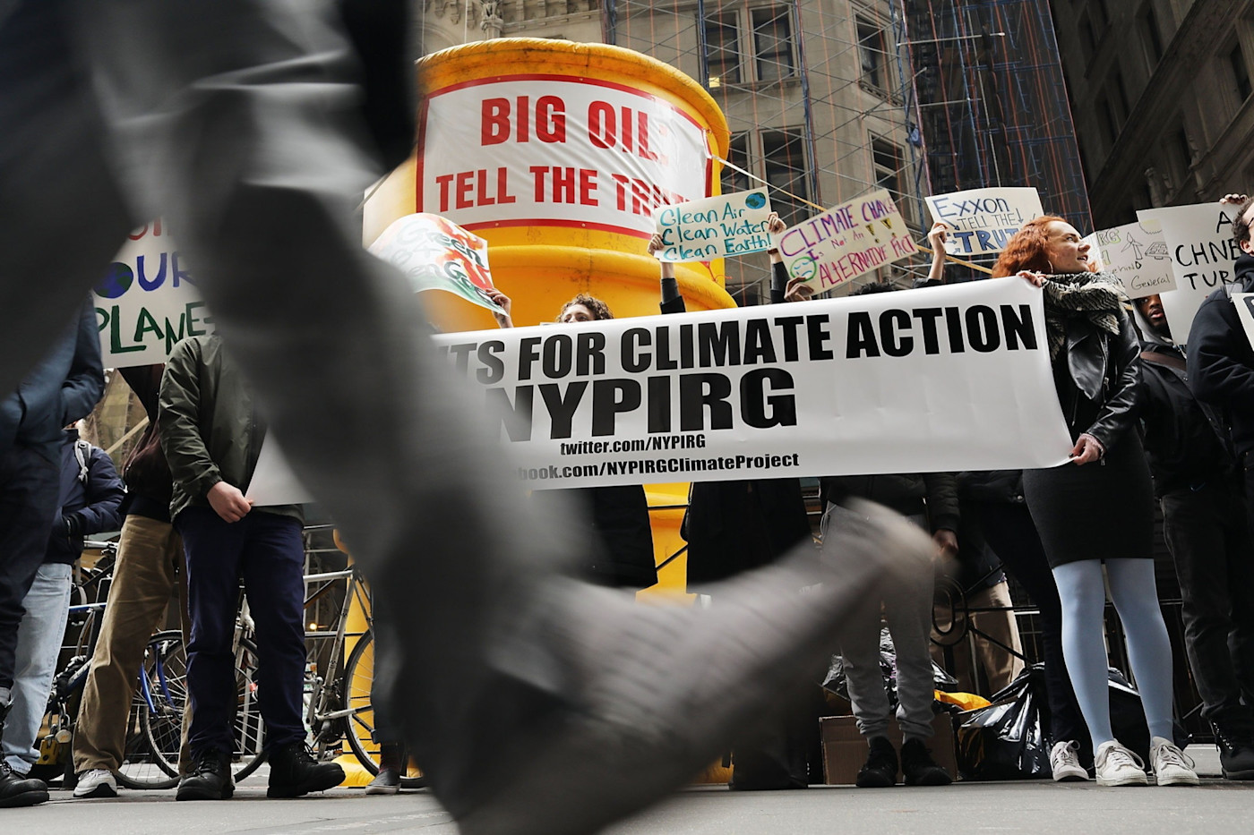 시위대가 ‘Big Oil, Tell The Truth’라고 적힌 대형 풍선 석유통 앞에서 NYPIRG 현수막과 기후 행동 관련 손팻말을 들고 있다.