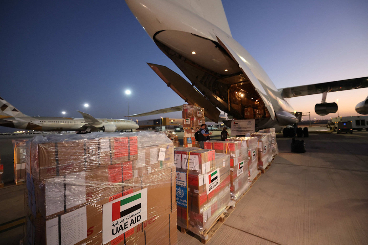 해질 무렵 공항에서 근로자들이 ‘UAE AID’와 ‘World Health Organization’이라고 적힌 구호물자를 수단행 화물기에 싣고 있다.