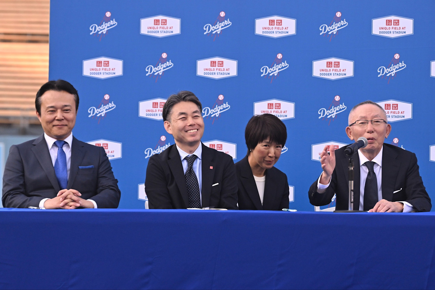 오른쪽의 야나이 다다시가 LA Dodgers 스타디움에서 Uniqlo와 야구팀 간 스포츠 파트너십을 발표하고 있다.