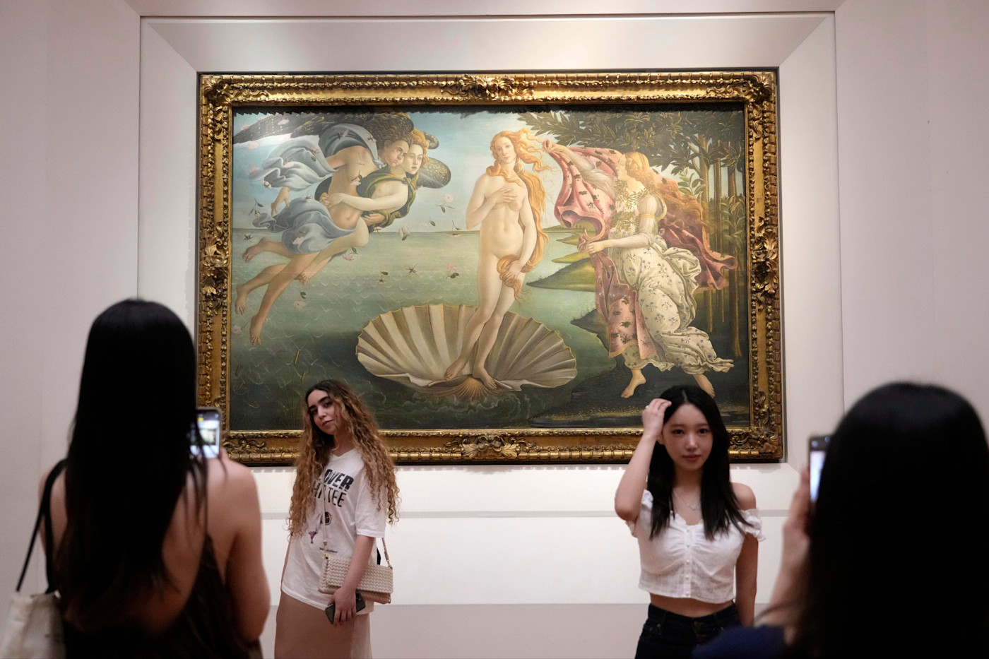 우피치 미술관에서 두 관광객이 산드로 보티첼리의 그림 《비너스의 탄생》 앞에서 기념사진을 찍고 있다.