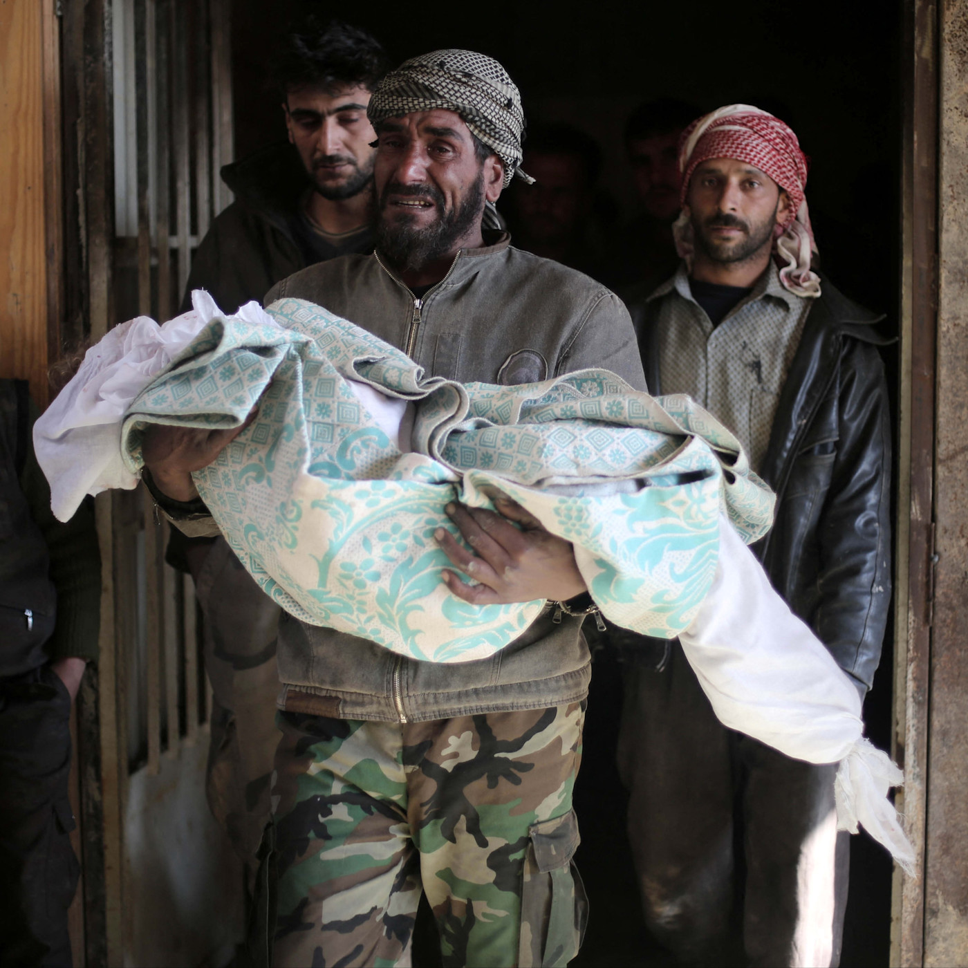 A grieving man carries the covered body of his ten-year-old daughter Maram, reportedly killed in airstrikes, before her funeral.