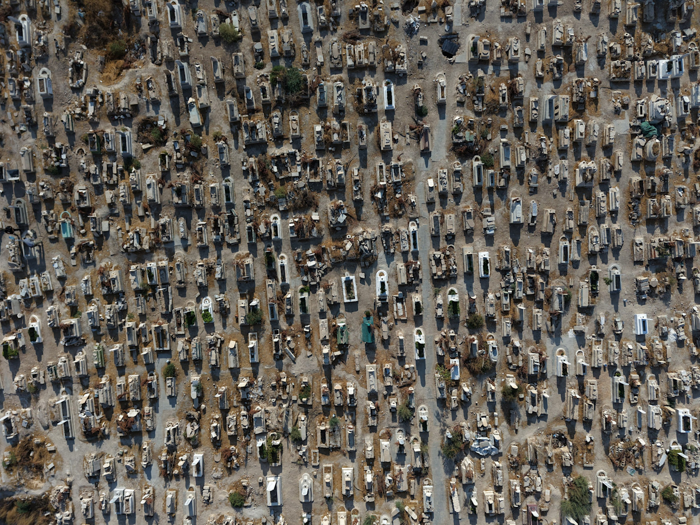 Rows of tightly packed graves in a cemetery, seen from above, with pathways between the graves.