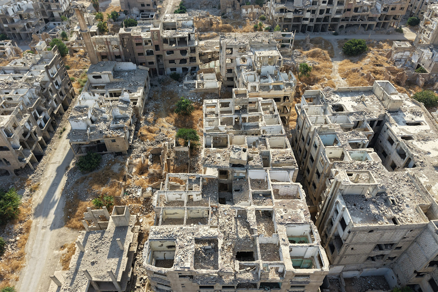 Aerial view of heavily damaged and abandoned buildings in Jobar, Syria, with rubble and debris covering the area.